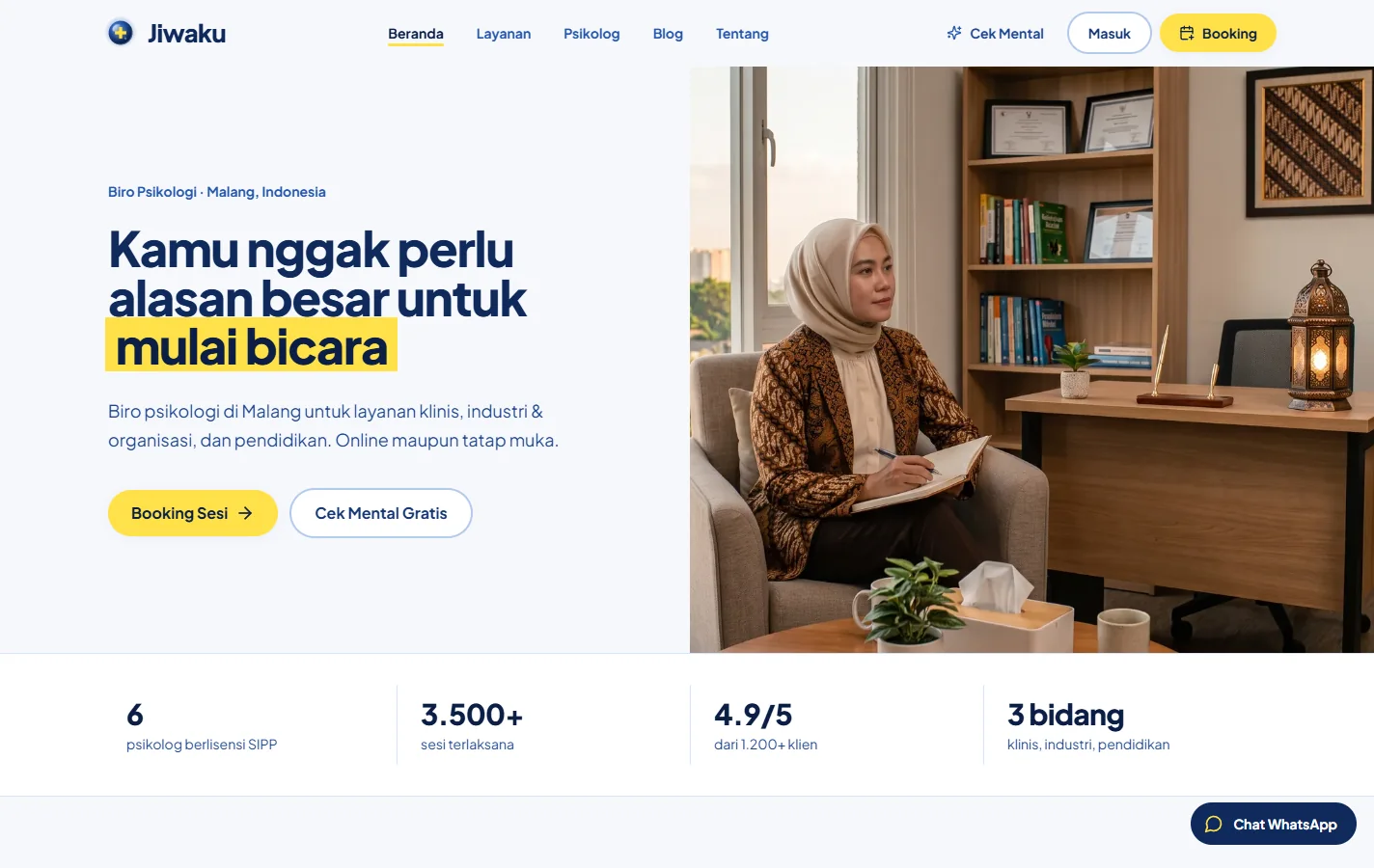 Jiwaku home page in white, navy and yellow, with an Indonesian headline inviting visitors to start talking, Booking and free mental check buttons, and a photograph of a psychologist taking notes in a consulting room.
